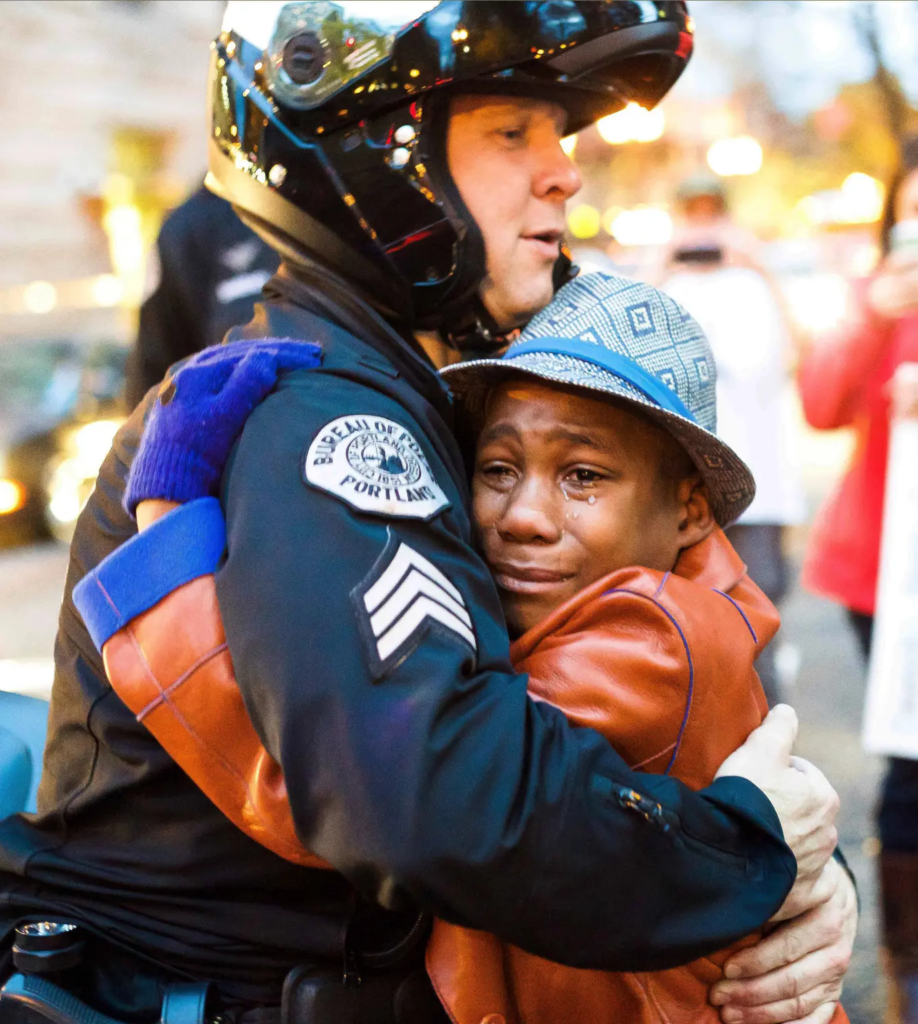 Devonte Hart hugs Portland officer Bret Barnum in a viral 2014 photo. AP
