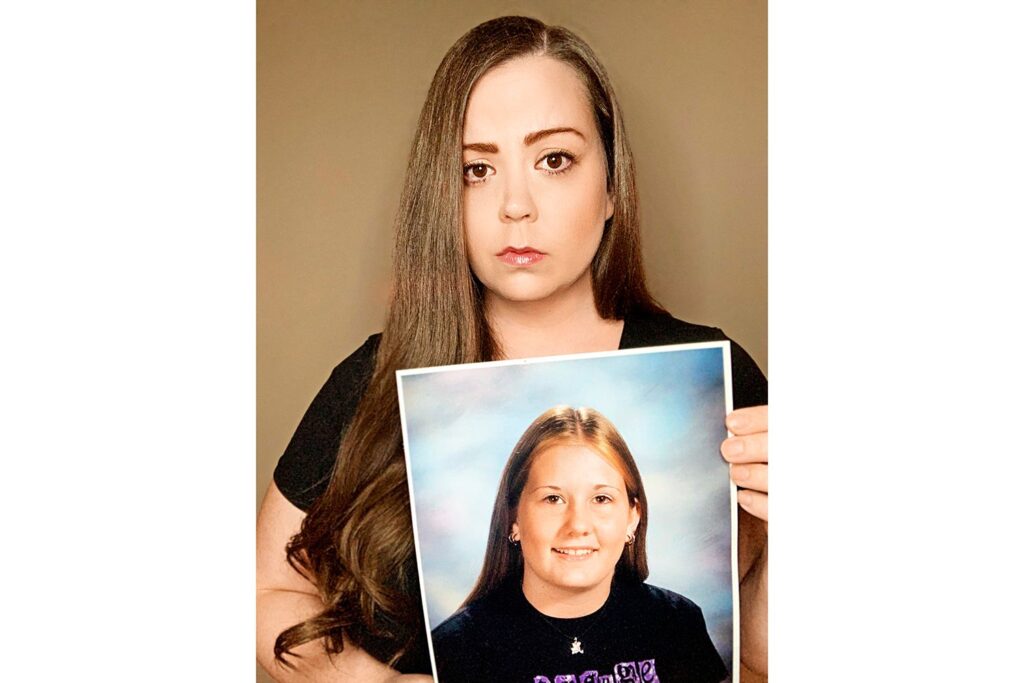 Sarah Turney holding a photo of her missing sister Alissa while recording a video for social media.
