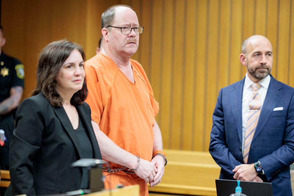 Dale Warner, 58, appears in Lenawee County Circuit Court in Adrian, Michigan, flanked by defense attorneys Mary Chartier and co-counsel, during proceedings in the murder case of his wife Dee Warner, 2026.