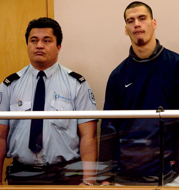 George Charlie Baker, 25, in court in Auckland, New Zealand, flanked by a Chubb Security guard. Baker was convicted of murdering 17-year-old Liam Ashley in a prison transport van on August 24, 2006.