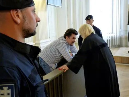 Evaldas Rimasauskas in a Lithuanian courtroom in Vilnius in 2017, consulting with a legal representative during extradition proceedings. He was later transferred to New York, where he was sentenced on December 19, 2019 to five years in federal prison and ordered to forfeit nearly $50 million.