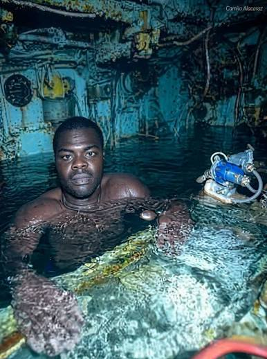 Harrison Okene inside the flooded hull of the sunken Jascon-4, breathing in a trapped air pocket 100 feet below the Atlantic. He had been there for nearly three days when divers finally found him. Nigeria, May 2013.