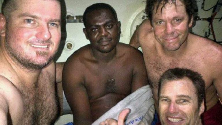 Harrison Okene inside the decompression chamber aboard the Lewek Toucan, photographed with members of the South African dive team who rescued him. He spent three days in the chamber before it was safe to return to the surface. Atlantic Ocean, May 2013.